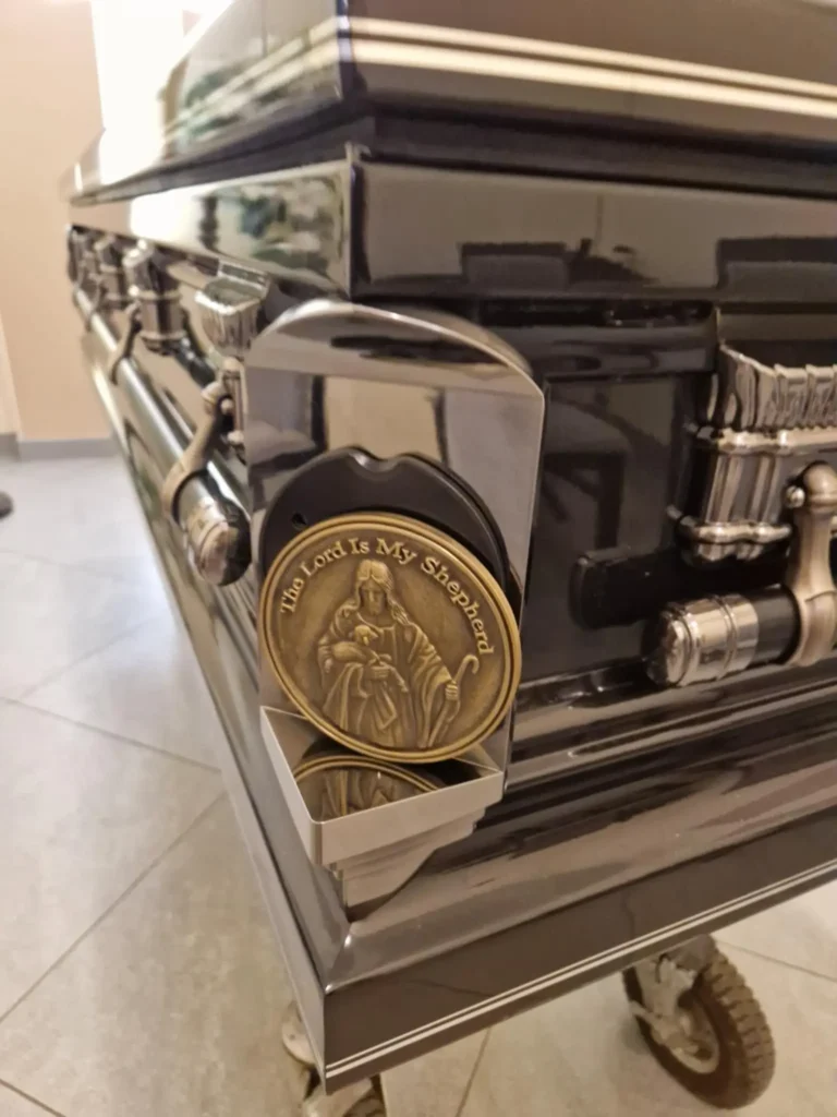 Trumna pogrzebowa z metalowym uchwytem i symbolem religijnym